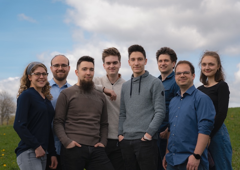 young man wearing shades and a hat with a beard, tattos and ear piercings