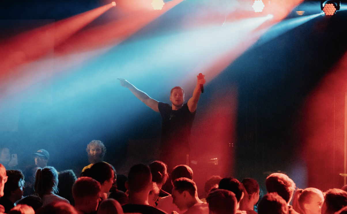 young man wearing shades and a hat with a beard, tattos and ear piercings